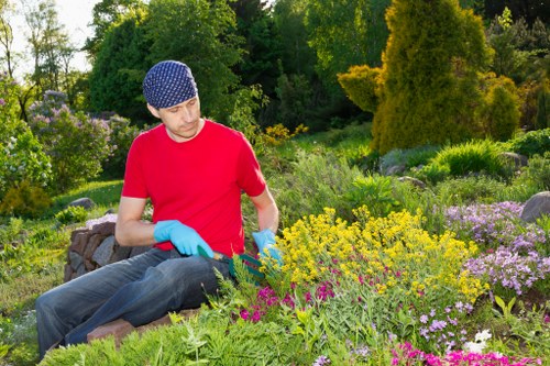 Workers handling garden waste and rubbish removal with protective equipment